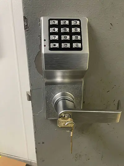 A door lock with keys on the outside of it.