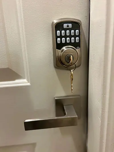 A door lock with keys and a key pad.